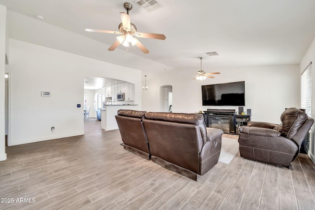 15019 W Banff Ln, Surprise, AZ 85379 - living room featuring arched walkways, a ceiling fan, light wood-style flooring, and lofted ceiling