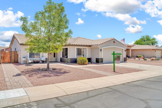 15019 W Banff Ln, Surprise, AZ 85379 - mediterranean / spanish-style house with stucco siding, a tile roof, a garage, concrete driveway, and a gate