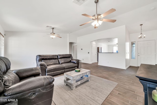 15019 W Banff Ln, Surprise, AZ 85379 - living area featuring a ceiling fan, wood finished floors, arched walkways, and a chandelier