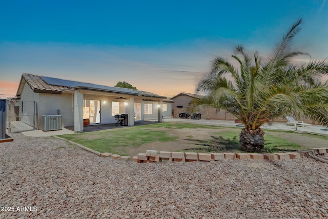 15019 W Banff Ln, Surprise, AZ 85379 - rear view of house featuring a gate, roof mounted solar panels, a patio area, a ceiling fan, and stucco siding