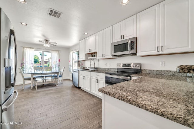 15019 W Banff Ln, Surprise, AZ 85379 - kitchen featuring stainless steel appliances, white cabinetry, recessed lighting, light wood-type flooring, and ceiling fan