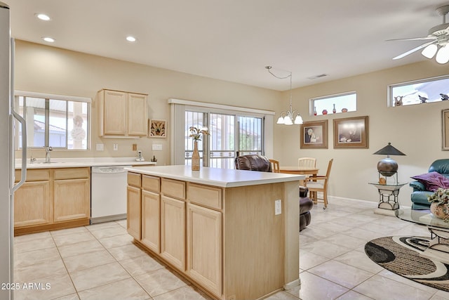 kitchen with light brown cabinets, white dishwasher, visible vents, and a wealth of natural light