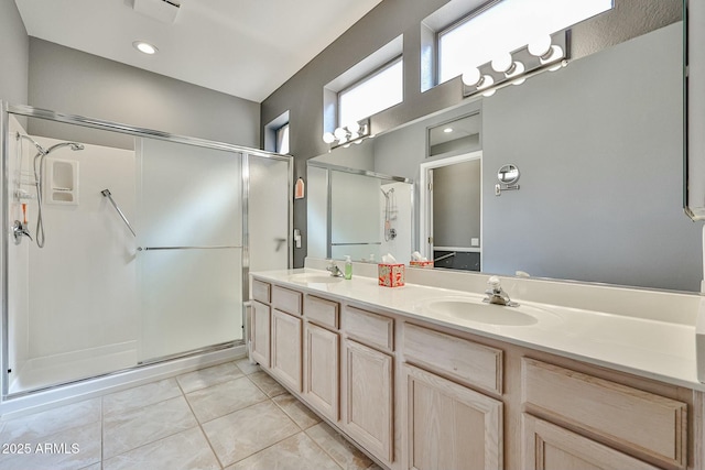 bathroom with a stall shower, tile patterned flooring, and a sink