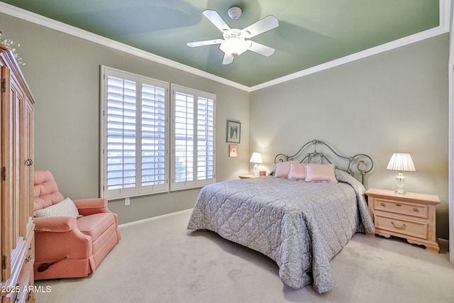 carpeted bedroom featuring ceiling fan, baseboards, and crown molding