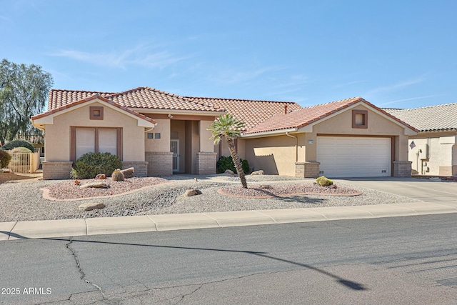 view of front facade with concrete driveway, a tiled roof, an attached garage, and stucco siding