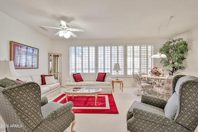 carpeted living area featuring visible vents and ceiling fan with notable chandelier