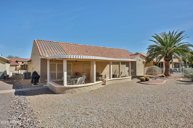 rear view of property featuring a patio, fence, central AC unit, and stucco siding