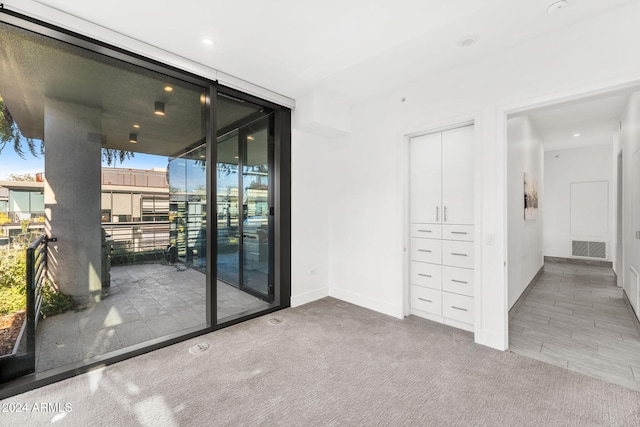 carpeted empty room with floor to ceiling windows