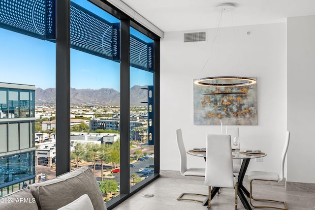 dining room with a mountain view and a wall of windows