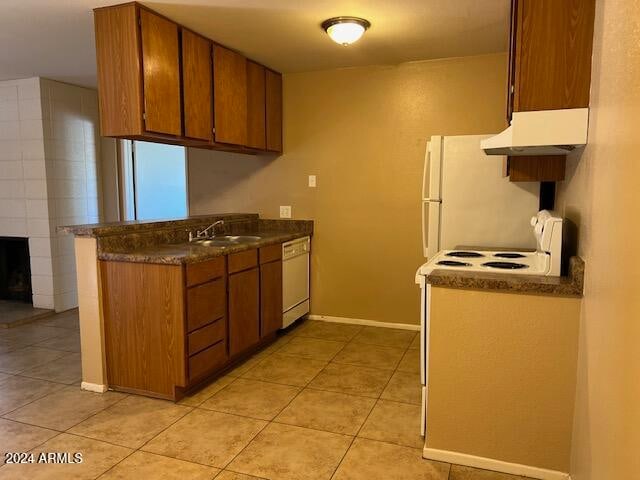 kitchen with white appliances, light tile patterned floors, and sink