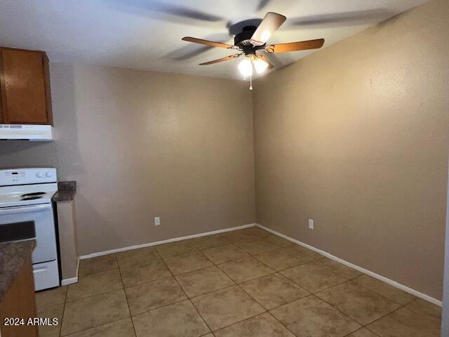 kitchen featuring ceiling fan, extractor fan, white range oven, and light tile patterned floors