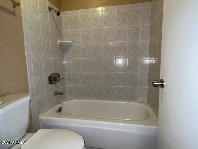 bathroom with tiled shower / bath and toilet