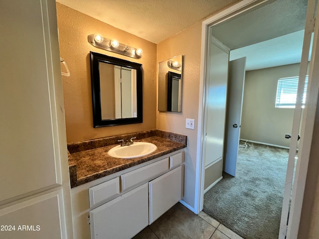 bathroom featuring vanity, a textured ceiling, and tile patterned floors