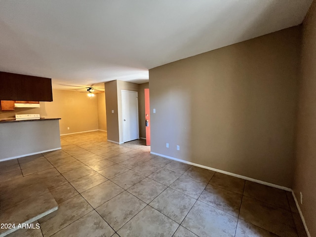 unfurnished living room featuring light tile patterned flooring and ceiling fan