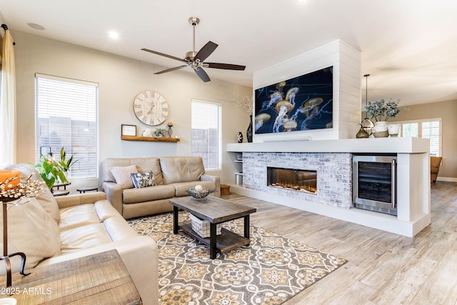 4422 E Spur Dr, Cave Creek, AZ 85331 - living room with wine cooler, a brick fireplace, wood finished floors, ceiling fan, and recessed lighting