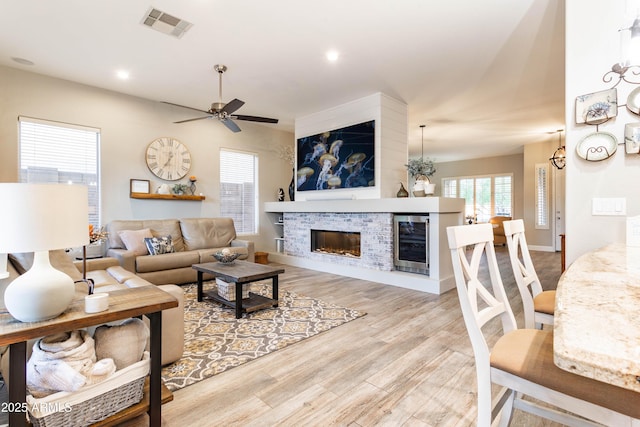 4422 E Spur Dr, Cave Creek, AZ 85331 - living area with wine cooler, a ceiling fan, a glass covered fireplace, light wood-style flooring, and recessed lighting