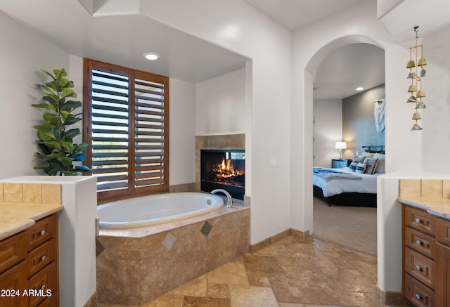 bathroom featuring vanity and tiled tub