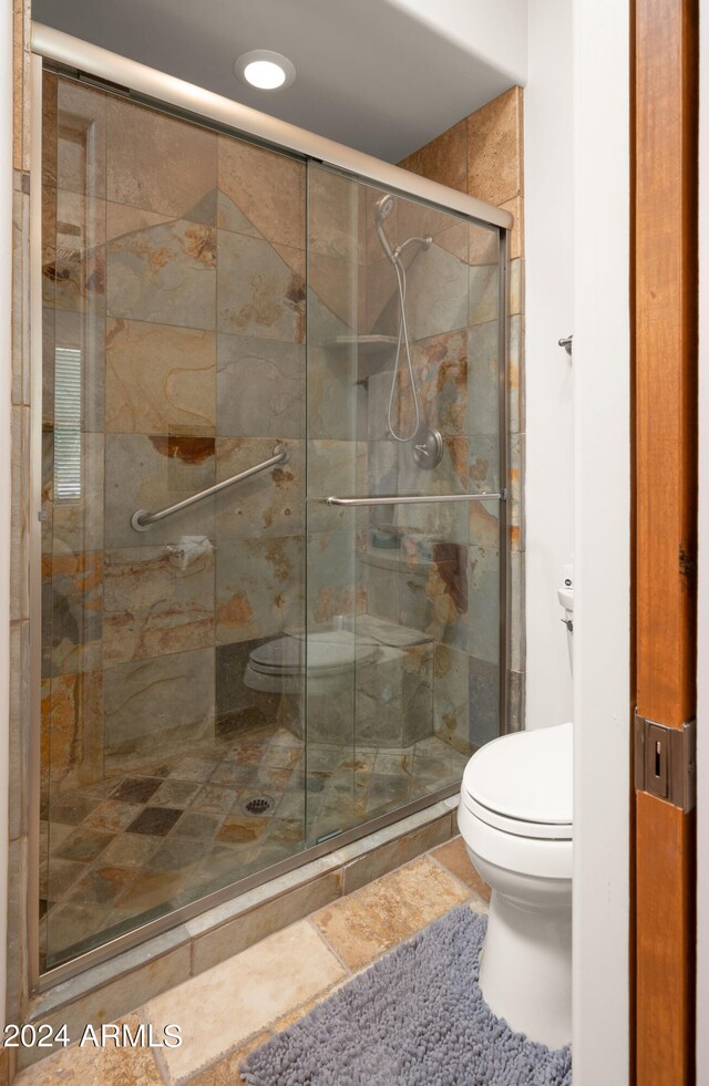 bathroom with tile patterned flooring, toilet, and walk in shower