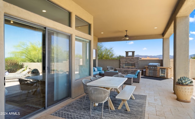 view of patio / terrace featuring an outdoor living space with a fireplace and ceiling fan