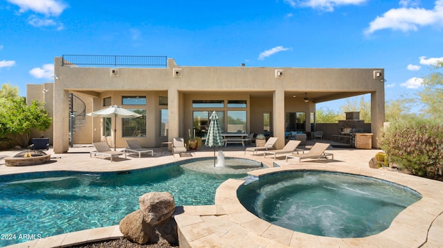 back of property with a patio area, a balcony, an outdoor kitchen, and a pool with hot tub