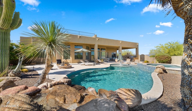 view of swimming pool featuring an in ground hot tub, a patio, and an outdoor fire pit