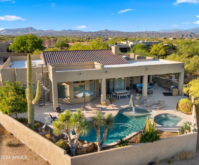 exterior space with outdoor lounge area, a mountain view, a patio, and a pool with hot tub