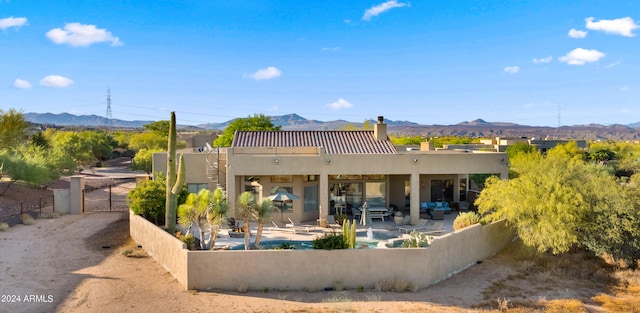 rear view of house with a mountain view and a patio