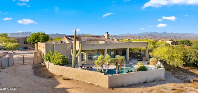 rear view of house with a mountain view and a patio area