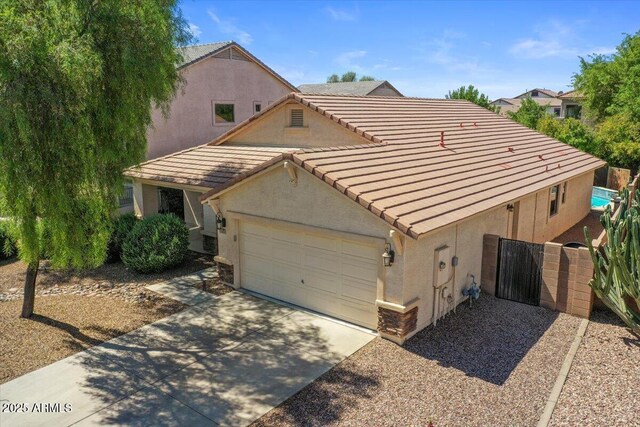 45131 W Horse Mesa Rd, Maricopa, AZ 85139 - view of front of property with a tiled roof, stucco siding, an attached garage, concrete driveway, and a gate