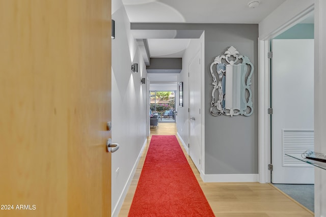 corridor with hardwood / wood-style flooring