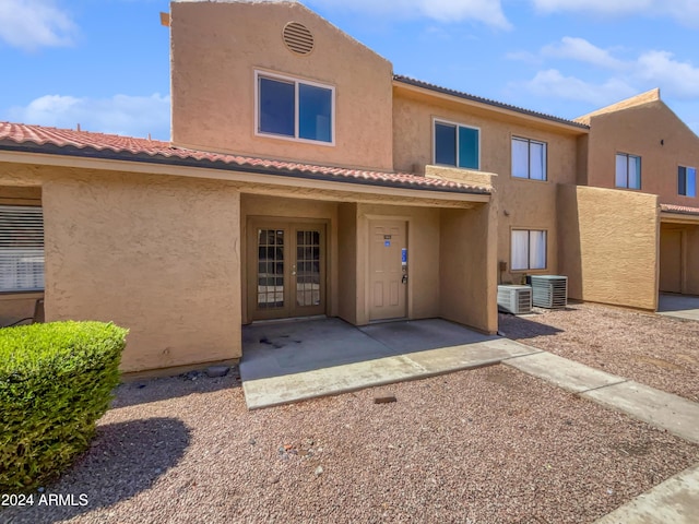 rear view of property featuring french doors and cooling unit