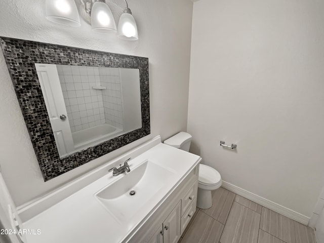 full bathroom with vanity, tiled shower / bath combo, and toilet