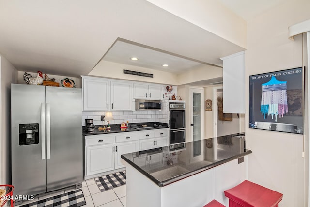 kitchen featuring white cabinetry, stainless steel appliances, decorative backsplash, and kitchen peninsula