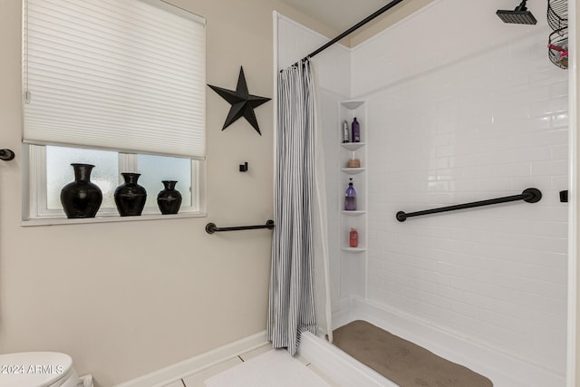 bathroom featuring tile patterned floors, a shower with shower curtain, and toilet