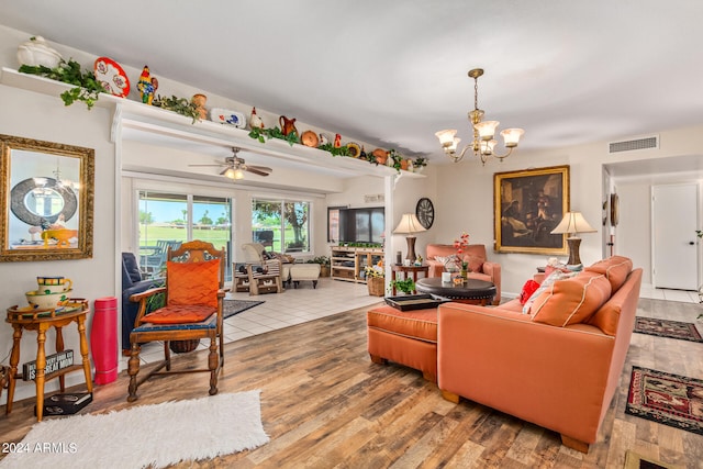 living room featuring wood-type flooring and ceiling fan with notable chandelier