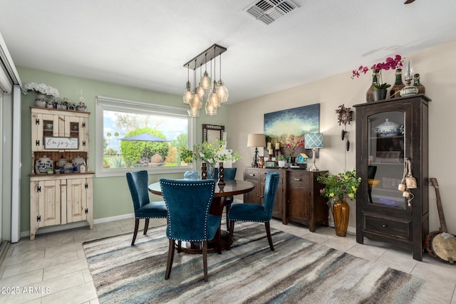 dining room featuring light tile patterned floors, visible vents, baseboards, and a notable chandelier