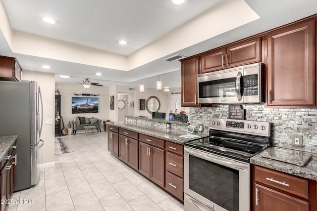 kitchen featuring ceiling fan, open floor plan, decorative backsplash, stone counters, and stainless steel appliances