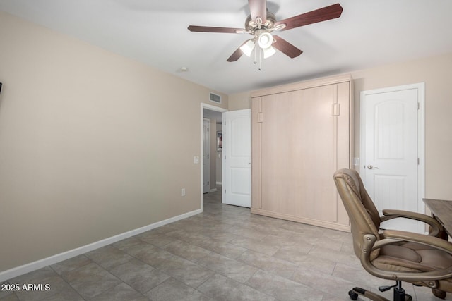 unfurnished office with baseboards, visible vents, and ceiling fan