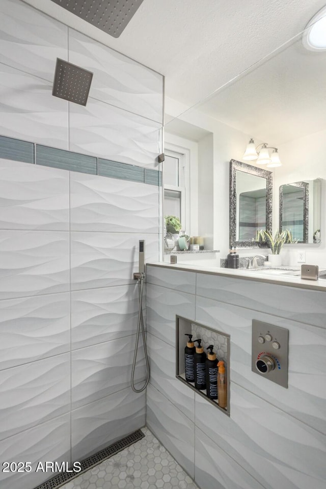 bathroom featuring a tile shower and vanity