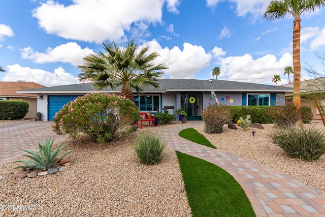 ranch-style house with decorative driveway and a garage