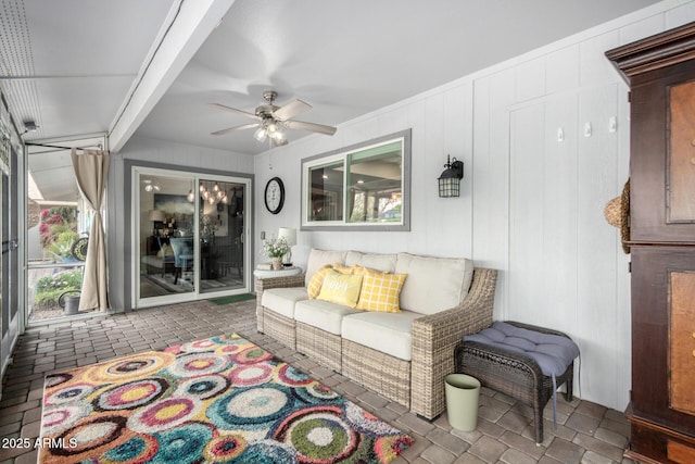 living room with a ceiling fan and brick floor