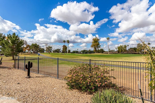 view of yard featuring view of golf course and fence