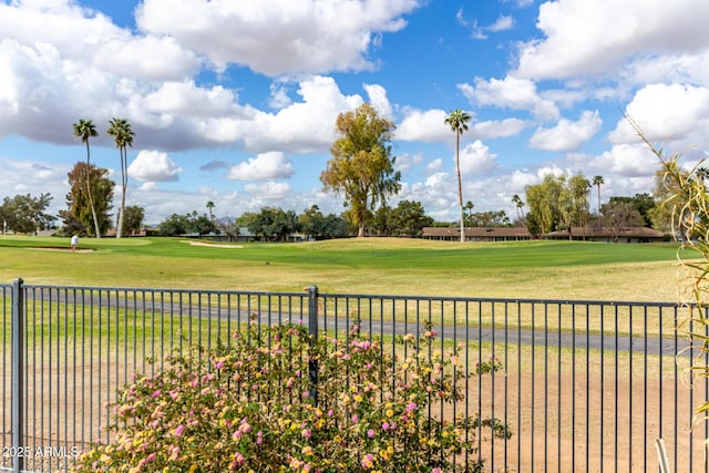 view of yard with fence and view of golf course