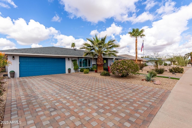 ranch-style home with decorative driveway and a garage