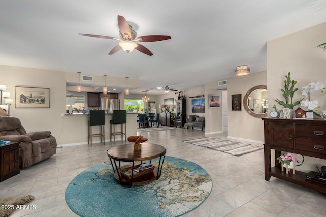 living room featuring a ceiling fan, visible vents, and baseboards