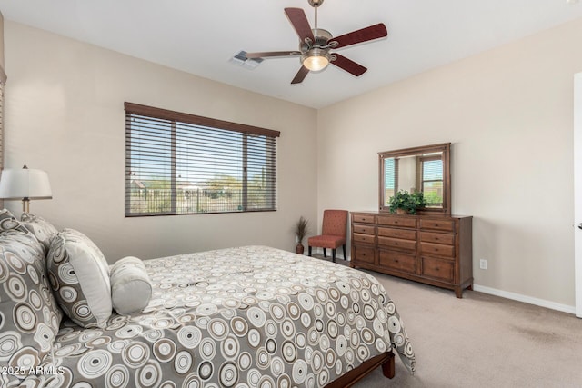 carpeted bedroom featuring multiple windows and ceiling fan