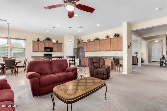 living room featuring light carpet and ceiling fan