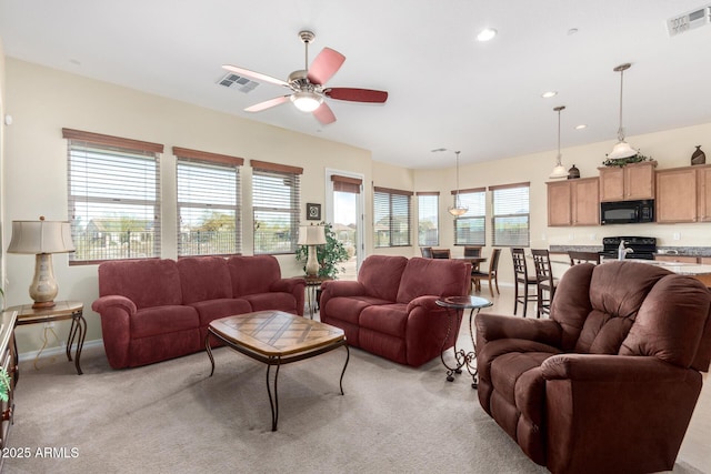 carpeted living room with ceiling fan