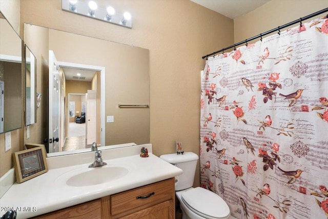 bathroom featuring a shower with curtain, vanity, and toilet