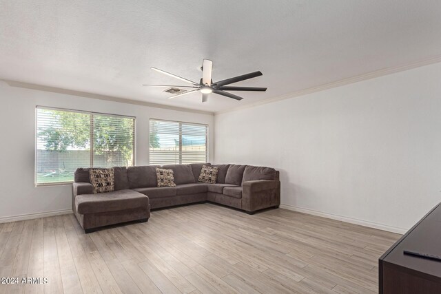 living room featuring ornamental molding, light hardwood / wood-style flooring, and ceiling fan